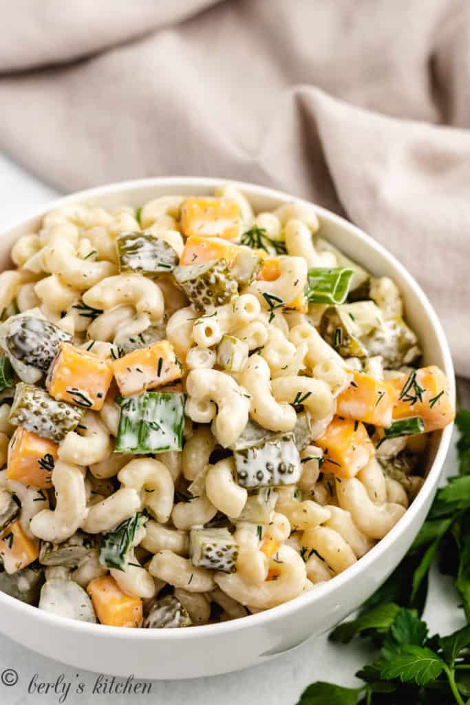 Top down view of dill pickle pasta salad in a white bowl.