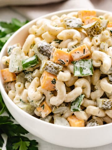 Large white bowl filled dill pickle pasta salad.
