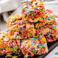 Fruity pebbles treats piled on a plate.