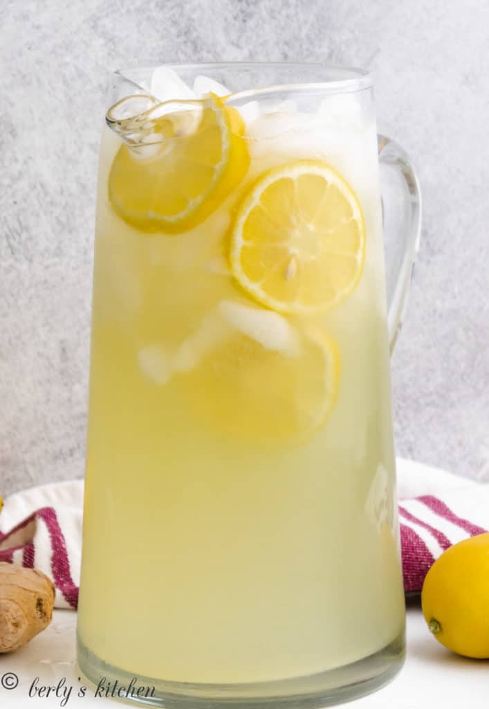 Tall pitcher filled with lemonade and ice.
