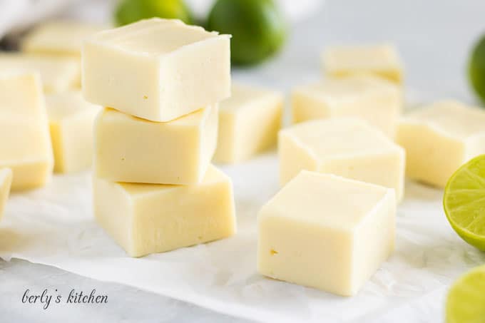 Multiple pieces of key lime fudge stacked on top of each other.