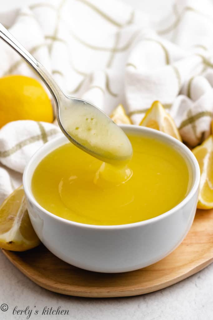 Spoon dipping lemon pastry filling.