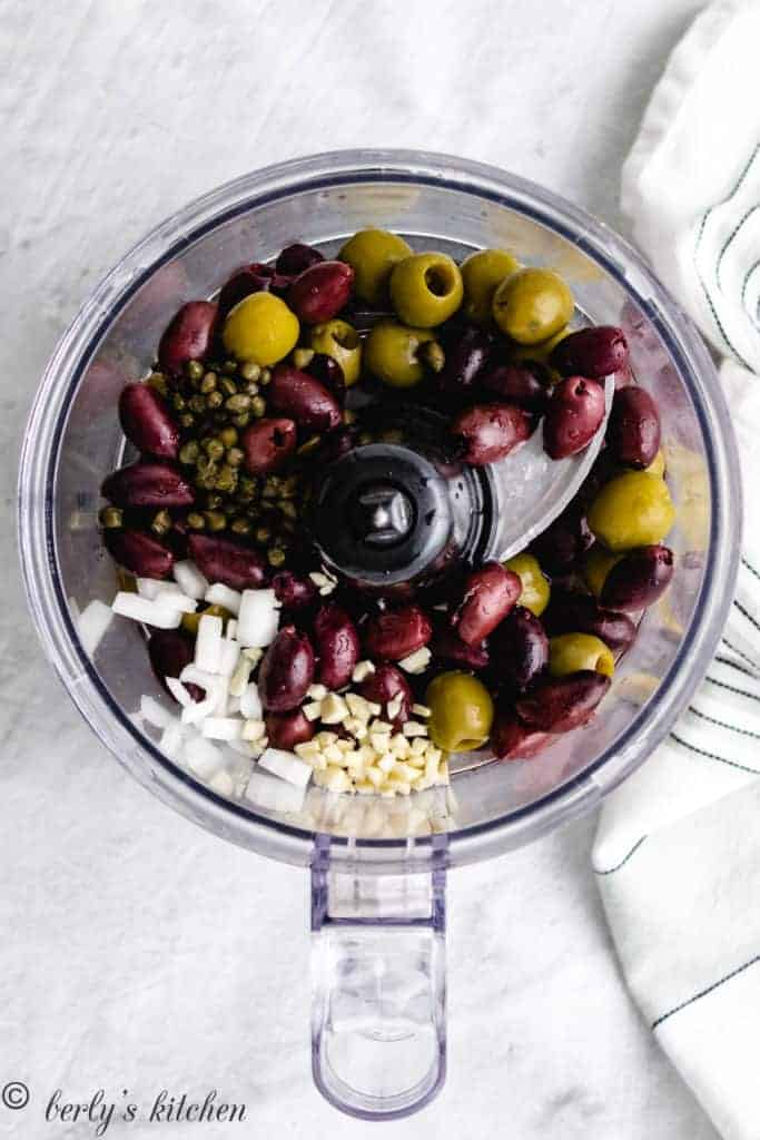 Top down view of ingredients of olive tapenade.