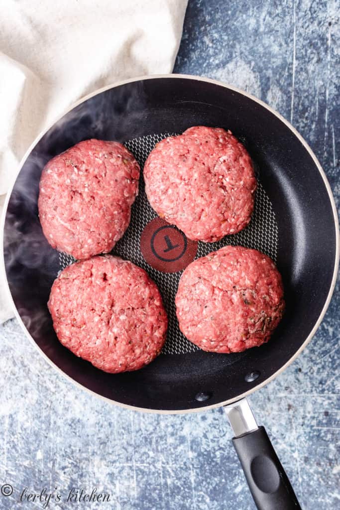 Top down photo of 4 raw burger patties.