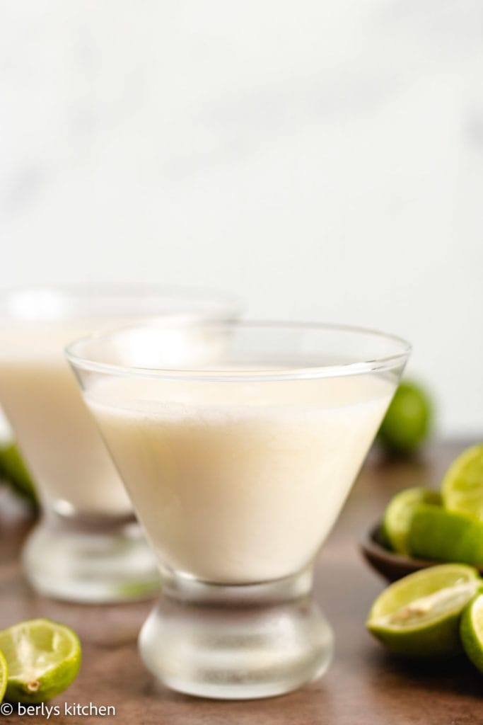 Key lime martini next to fresh key limes.