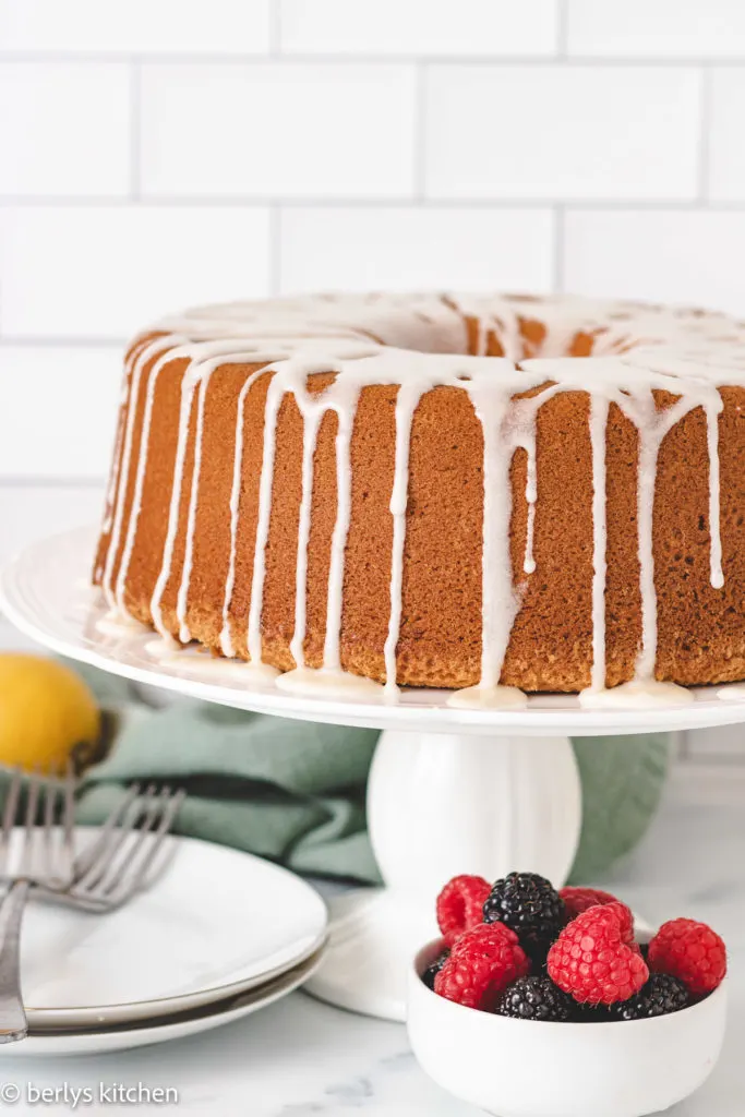 Pound cake drizzled with icing on a cake stand.