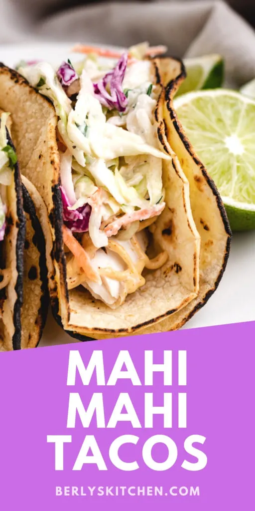 Two mahi mahi tacos on a plate.