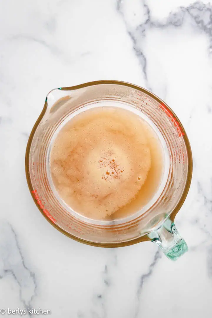 Top down view of peach syrup in a measuring cup.
