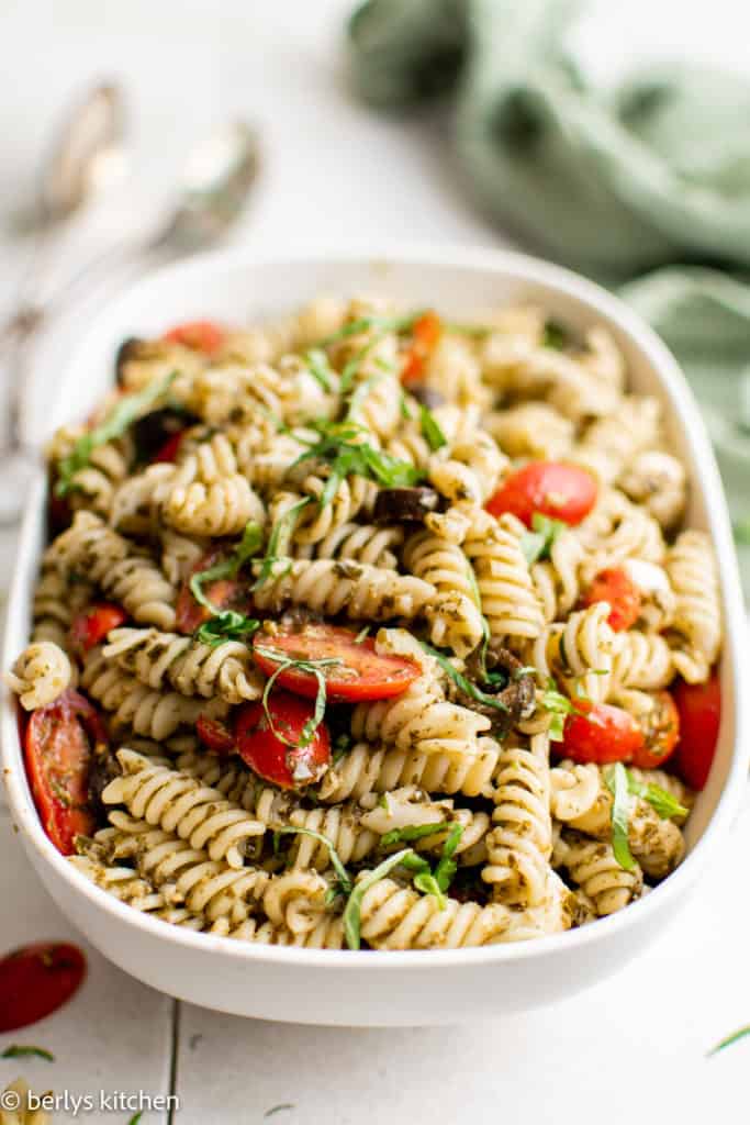 Serving dish filled with basil pesto pasta salad.