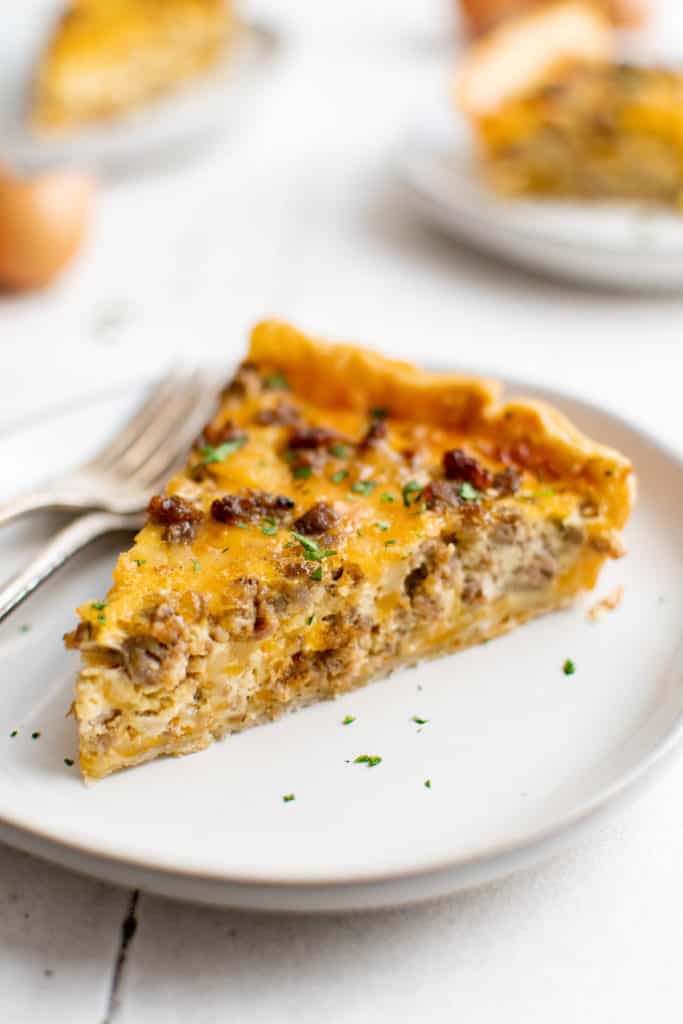 Quiche slice on a white plate.