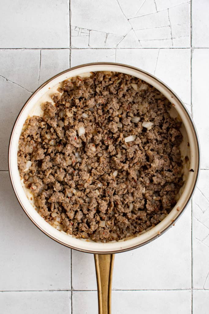 Top down view of cooked sausage in a pan.