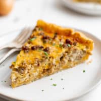 Slice of sausage quiche on plates.