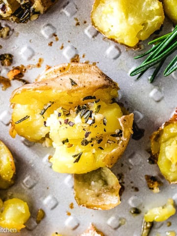 Top down view of baby gold potatoes on a pan with butter.