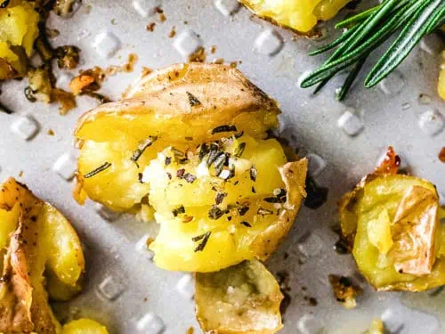 Top down view of baby gold potatoes on a pan with butter.