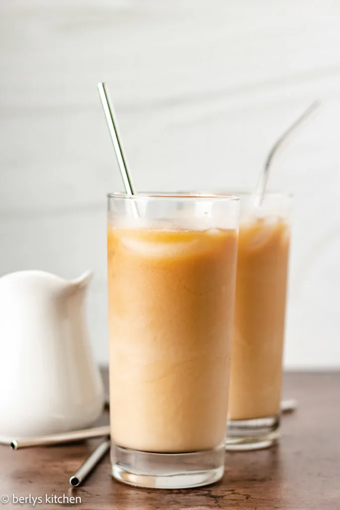 Two tall glasses filled with caramel flavored coffee.