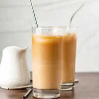 Two highball glasses filled with caramel coffee.