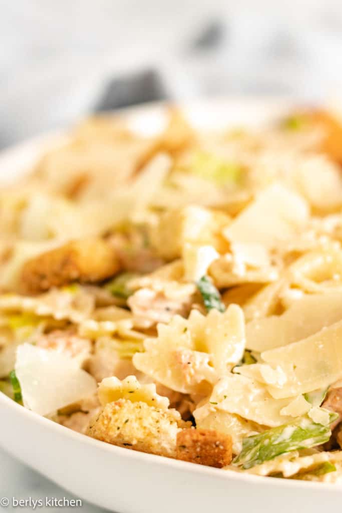 Bowtie chicken caesar pasta salad in a white bowl.