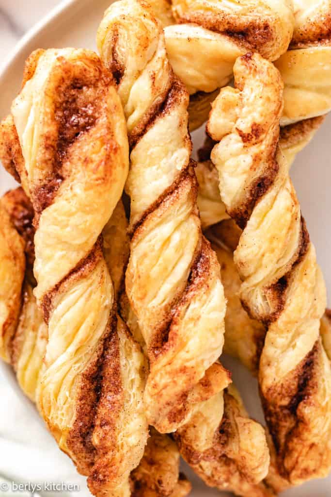 Top down view of several cinnamon twists on a plate.