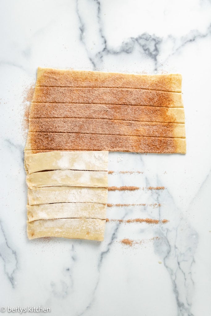 Dough with cinnamon sugar being twisted.