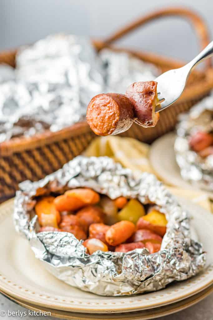 Open foil packet with veggies and sausage.