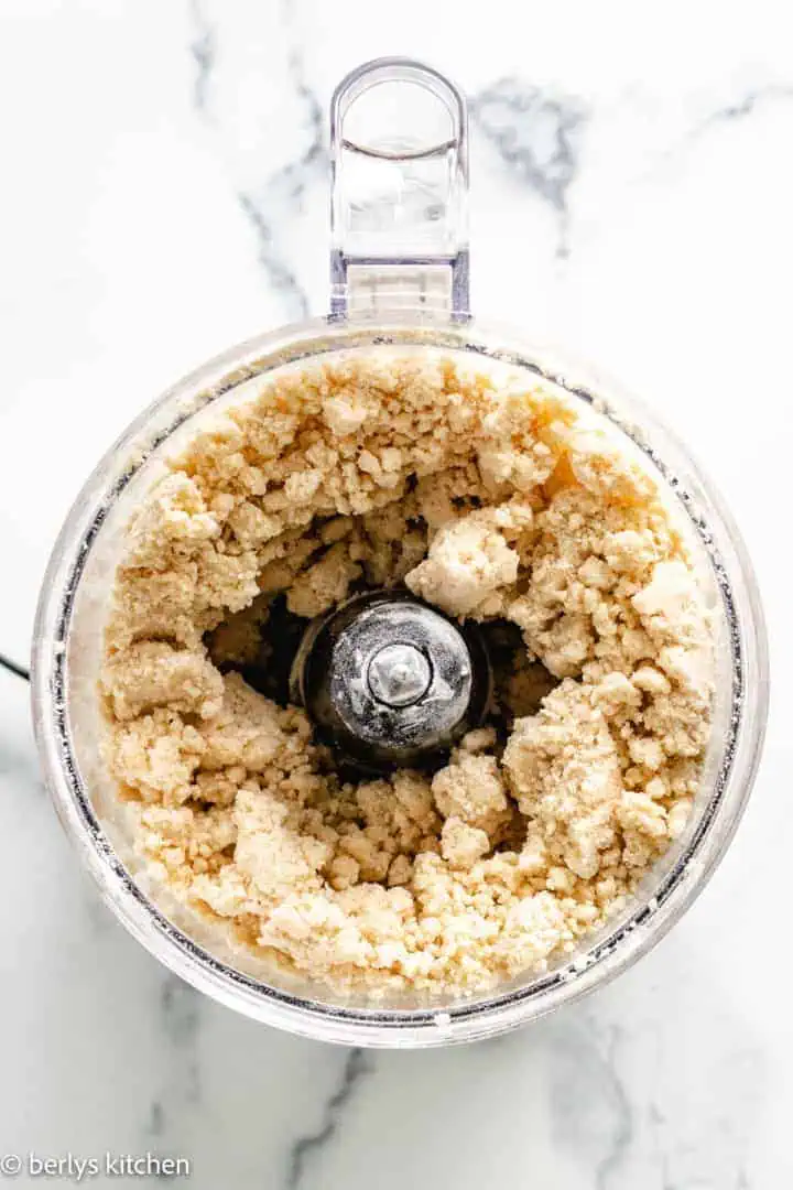 Top down view of pie crust made with butter in a food processor.