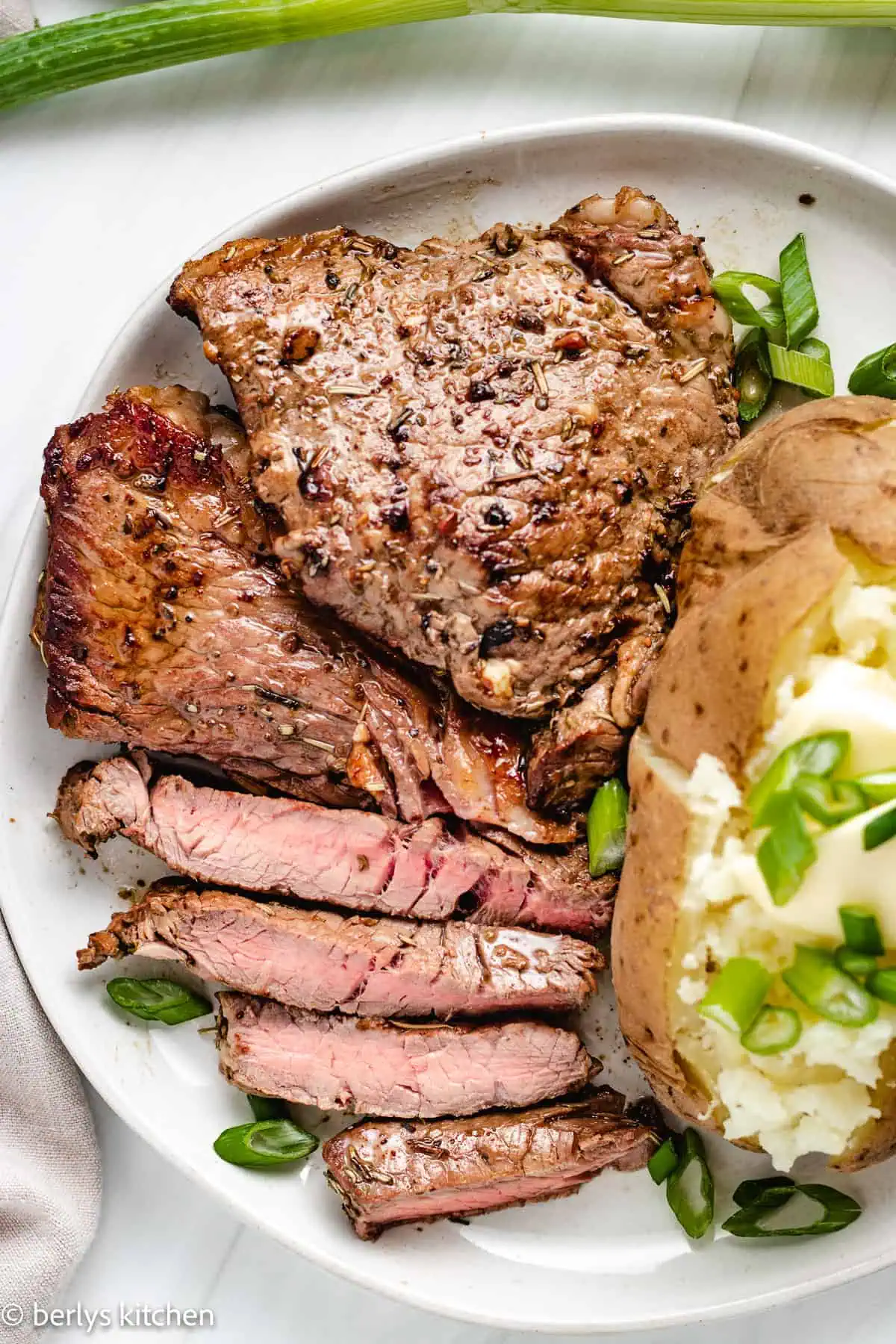 Top down view of steak on a gray plate.