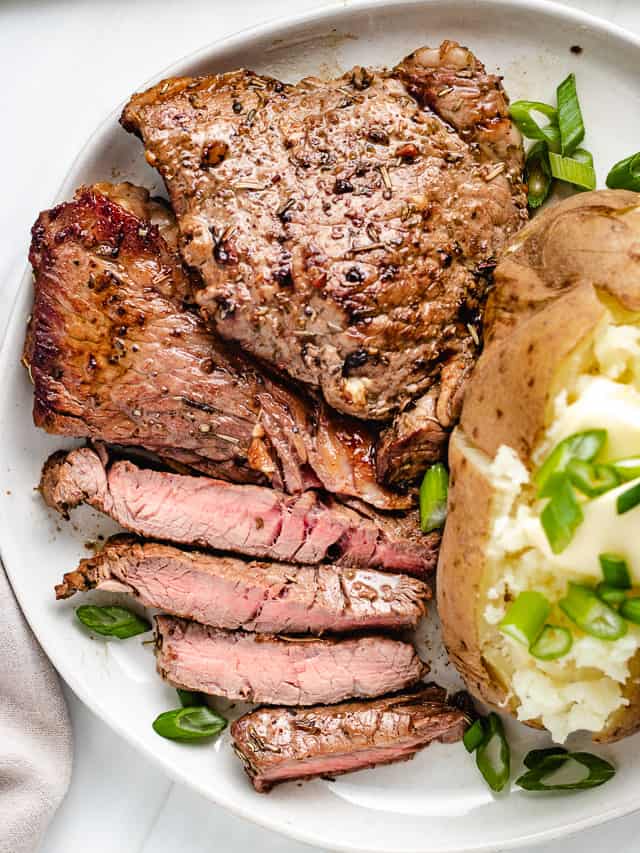 Top down view of steak and potato on a plate.