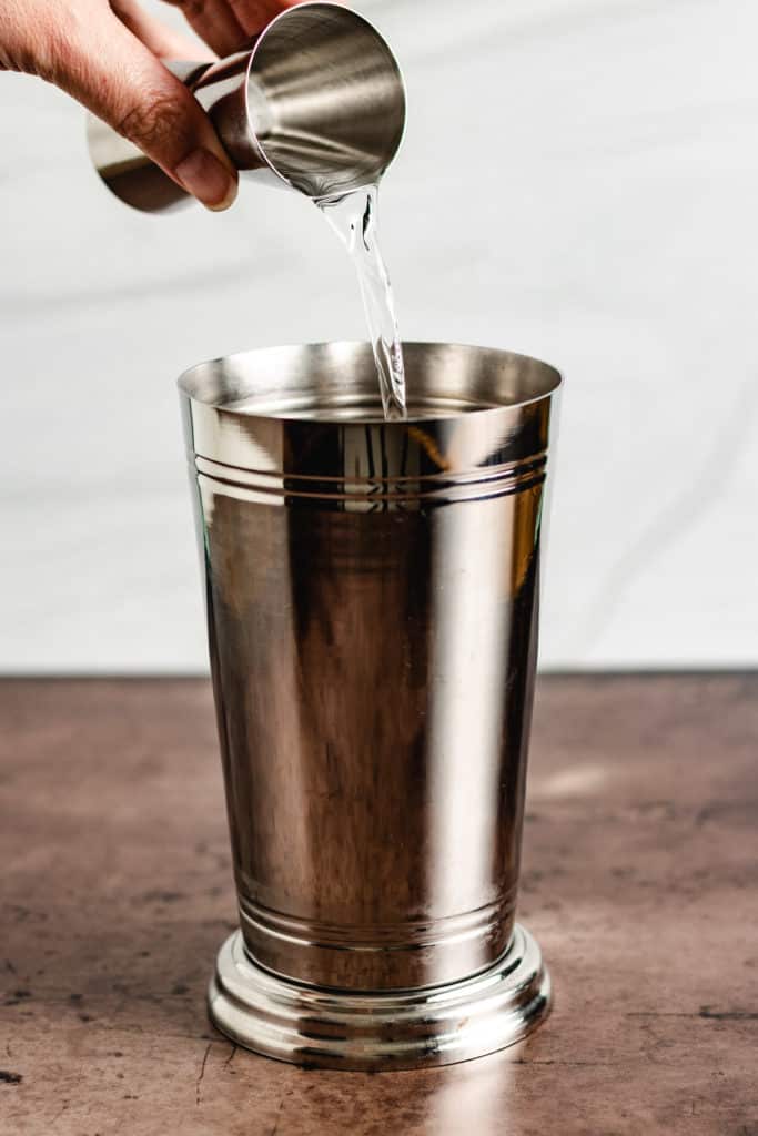 Caramel vodka being poured into a drink shaker.