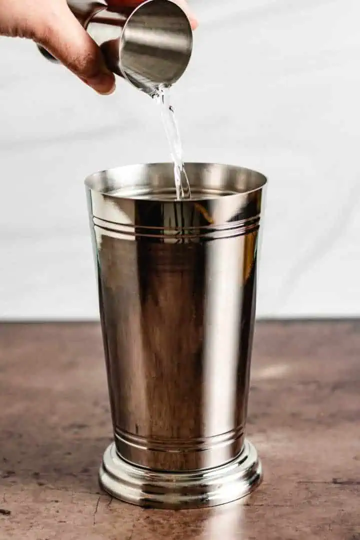 Butterscotch schnapps being poured into a drink shaker.