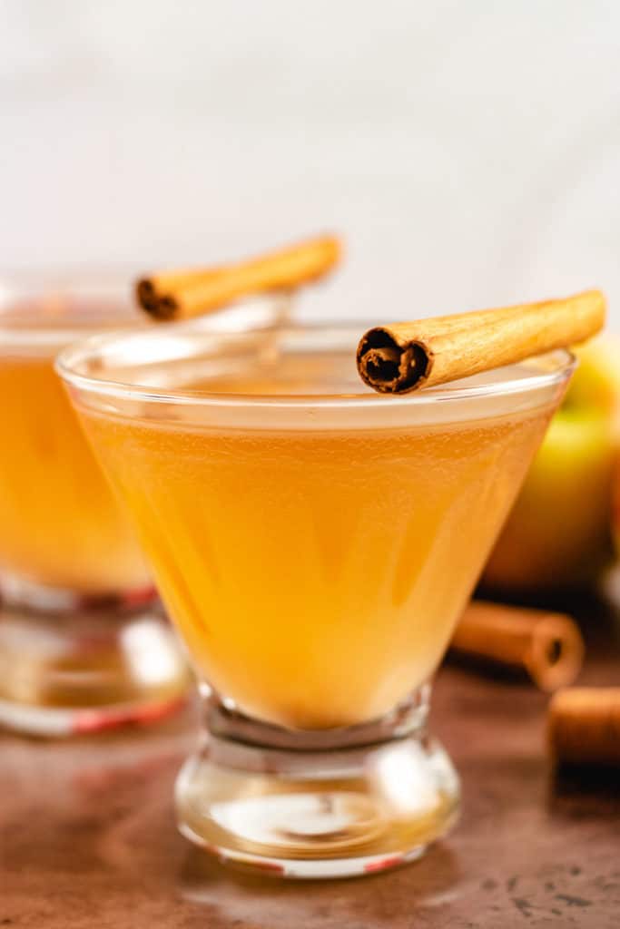 Two martinis with cinnamon sticks.