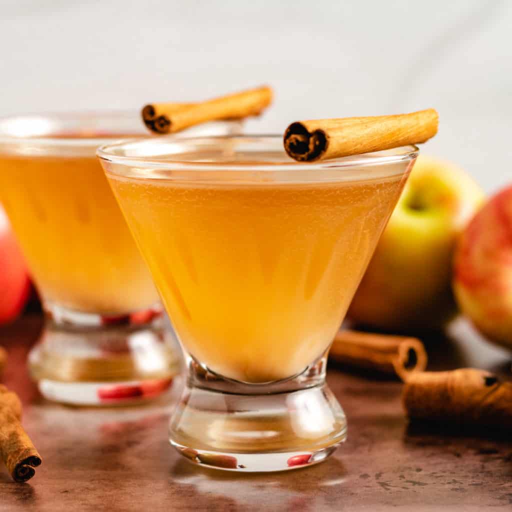 Two apple martinis with fresh apples.