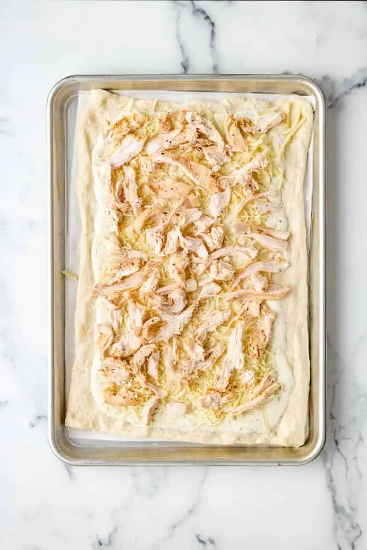 Top down view of shredded chicken on a baking dish.
