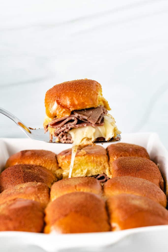 French dip slider being lifted out of a pan.