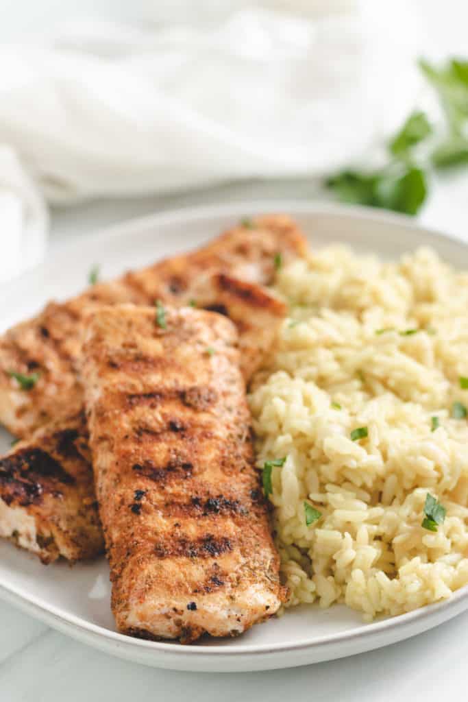 Close up view of grilled mahi mahi on a plate.