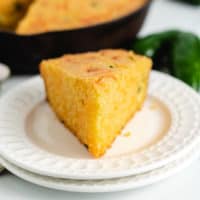 Slice of cornbread on 2 white plates.