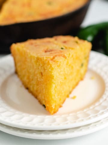Slice of cornbread on 2 white plates.