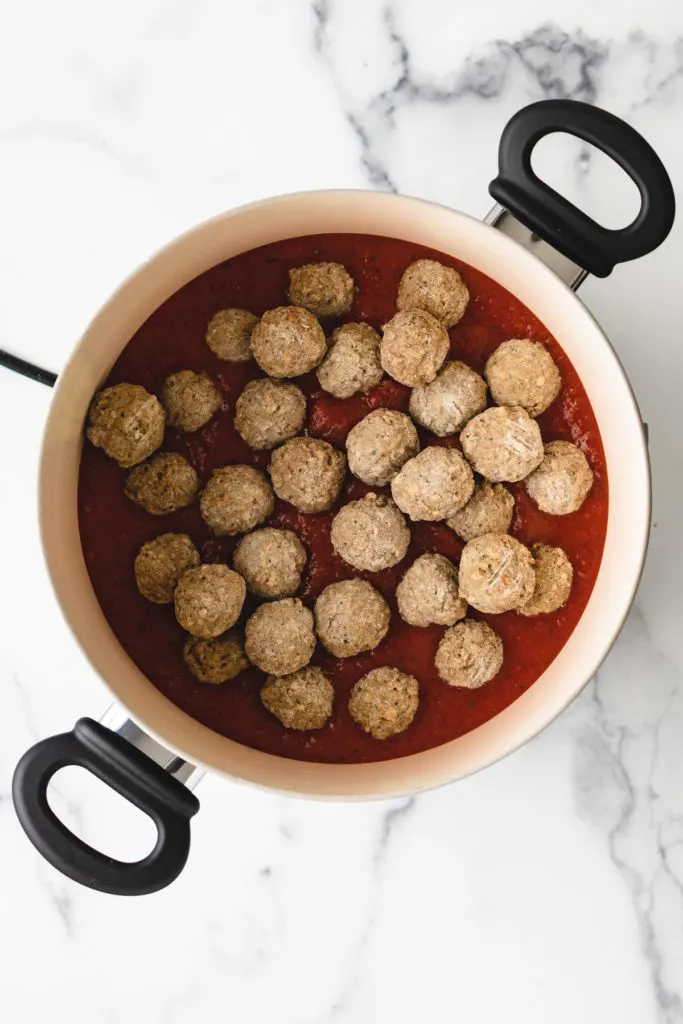 Top down view of frozen meatballs in marinara.