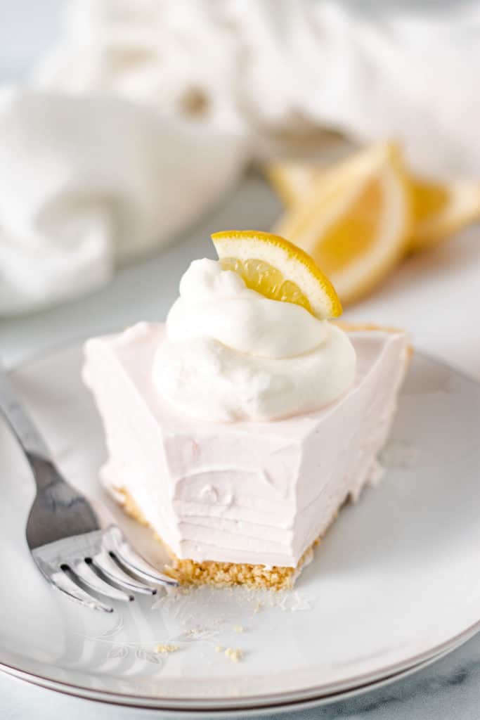 Slice of lemonade pie with a bite taken out.