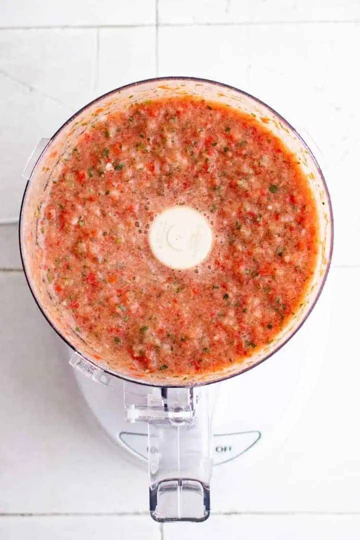 Top down view of salsa in a food processor.