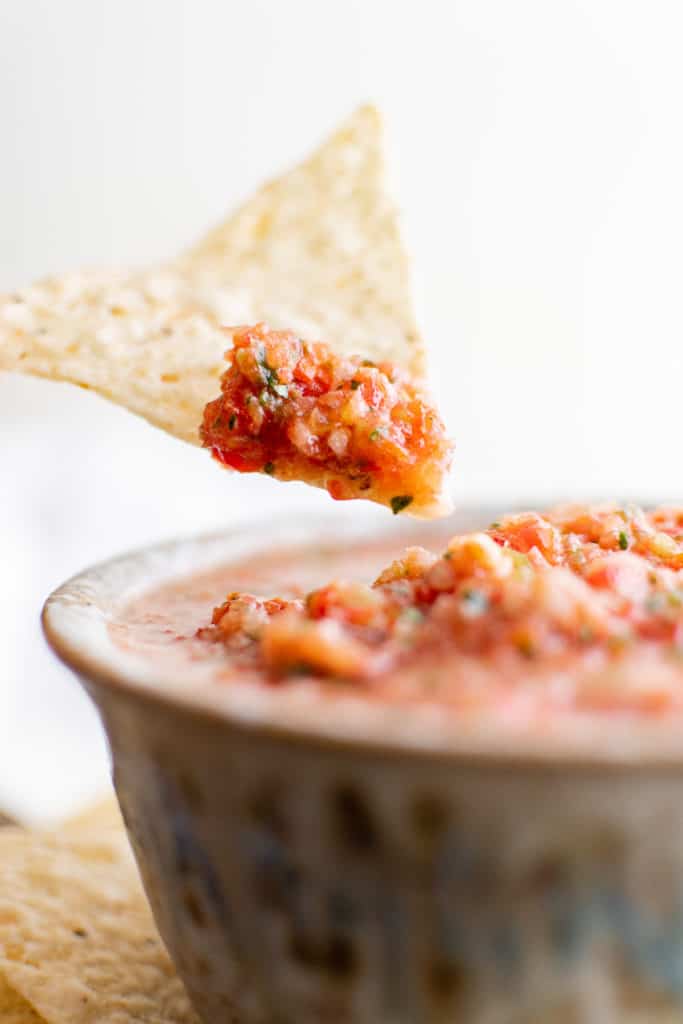 Chip being dipped in salsa.