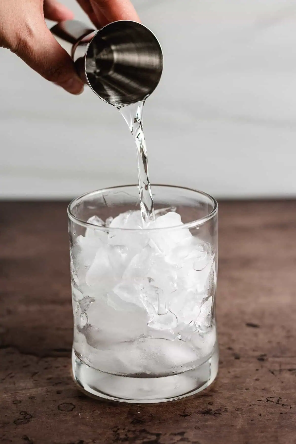 Vodka being poured over ice.