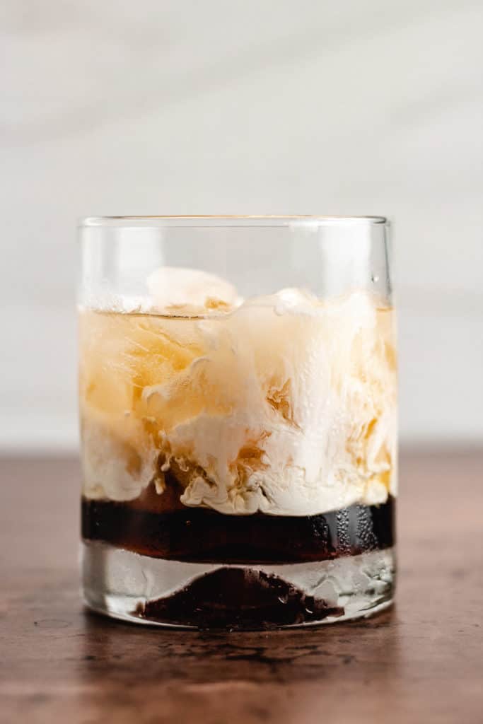 Cocktail glass filled with ice, liqueur, and heavy cream.