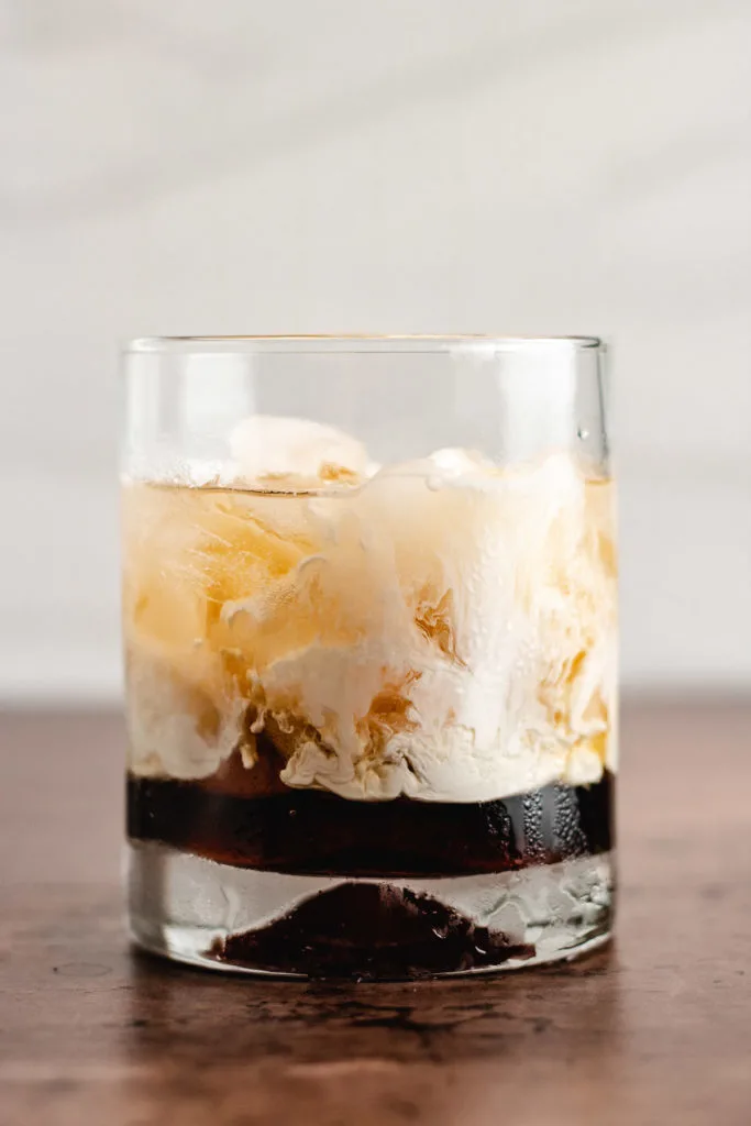 Cocktail glass filled with ice, liqueur, and heavy cream.