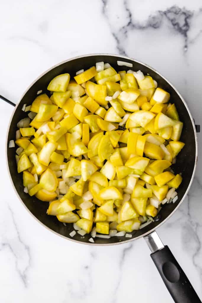 Top down view of cooked yellow squash in a pan.