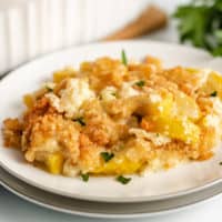 Yellow squash casserole served on a white plate.