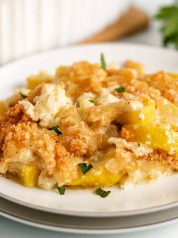 Yellow squash casserole served on a white plate.