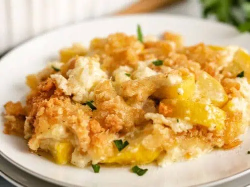 Yellow squash casserole served on a white plate.