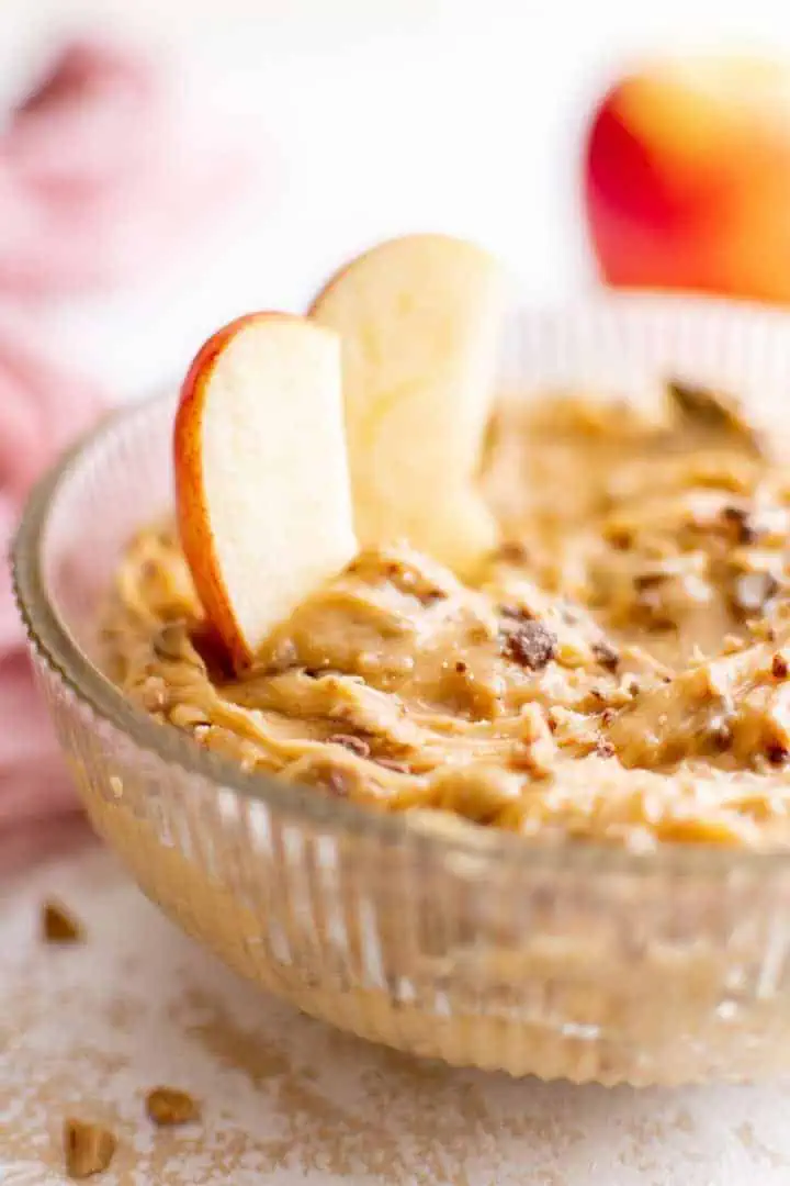 Apple slices in a bowl of caramel apple dip.