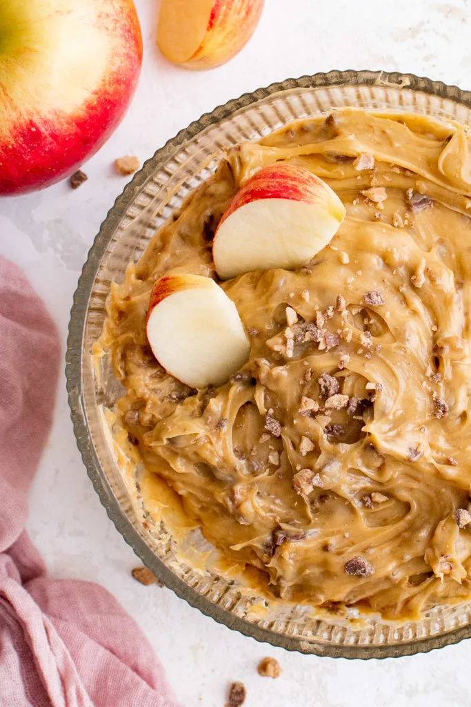 Caramel apple dip with apples in a bowl.