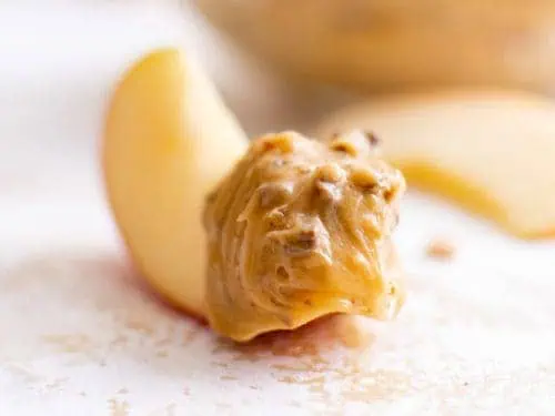 Apple slice dipped in caramel dip.